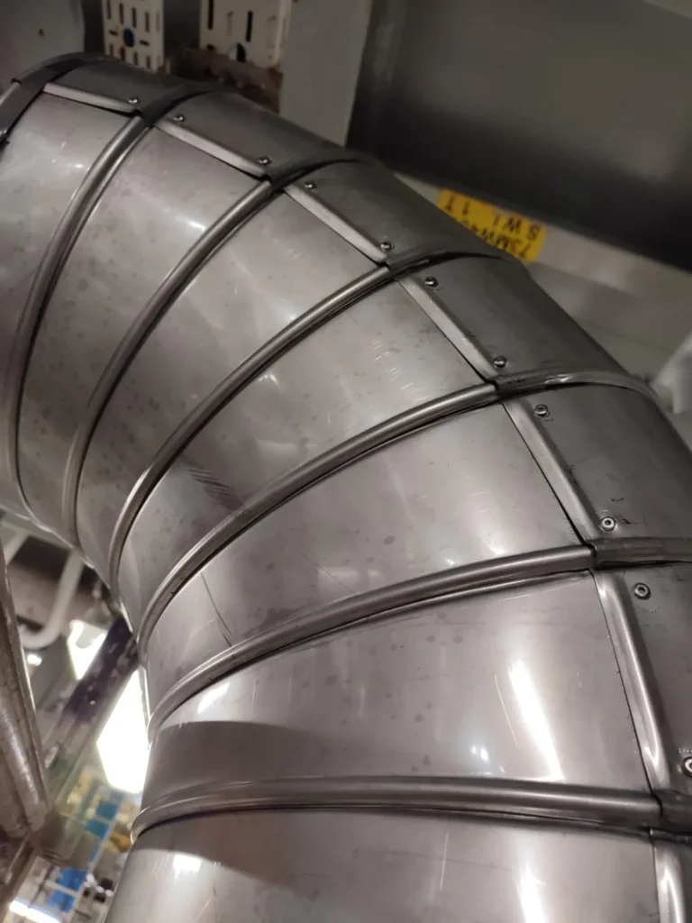 Ventilasjonskanal i rustfritt stål montert i industribygg